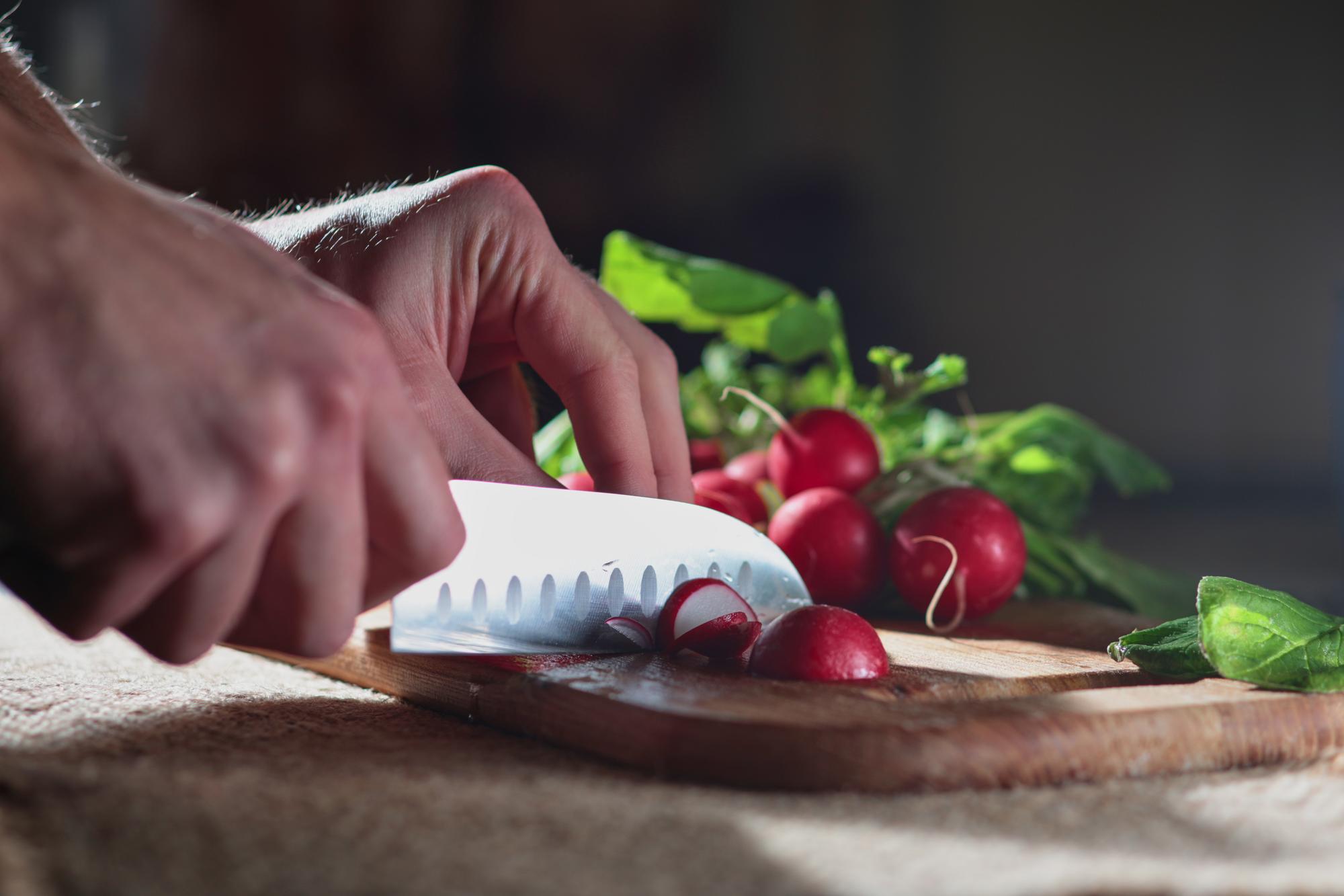 bucătar la lucru, prim-plan pe mâini și ingrediente proaspete